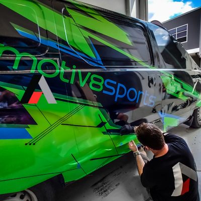 Car wrapping specialist putting vinyl foil or film on car.